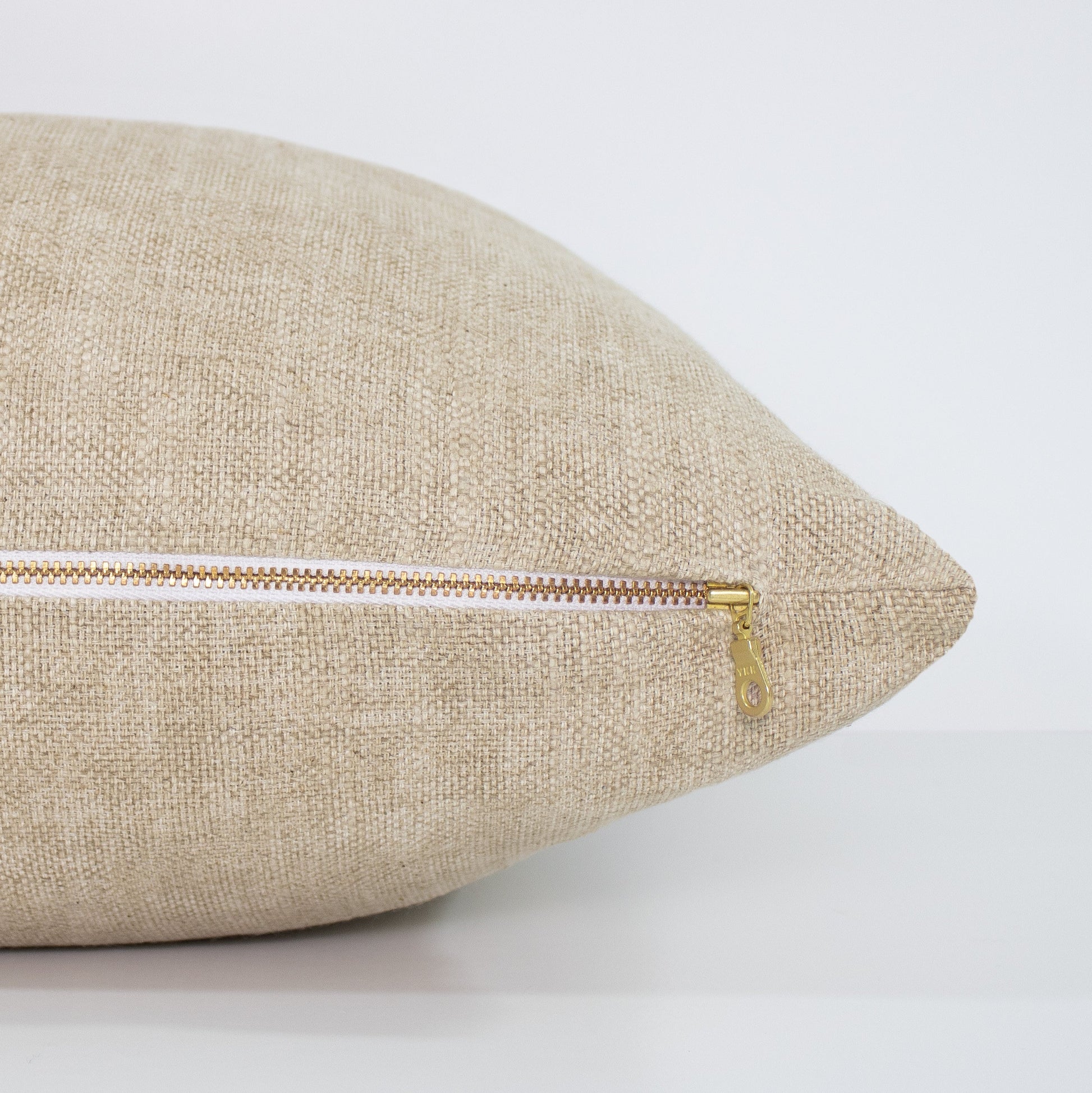 Beige pillow with a zipper on a white background