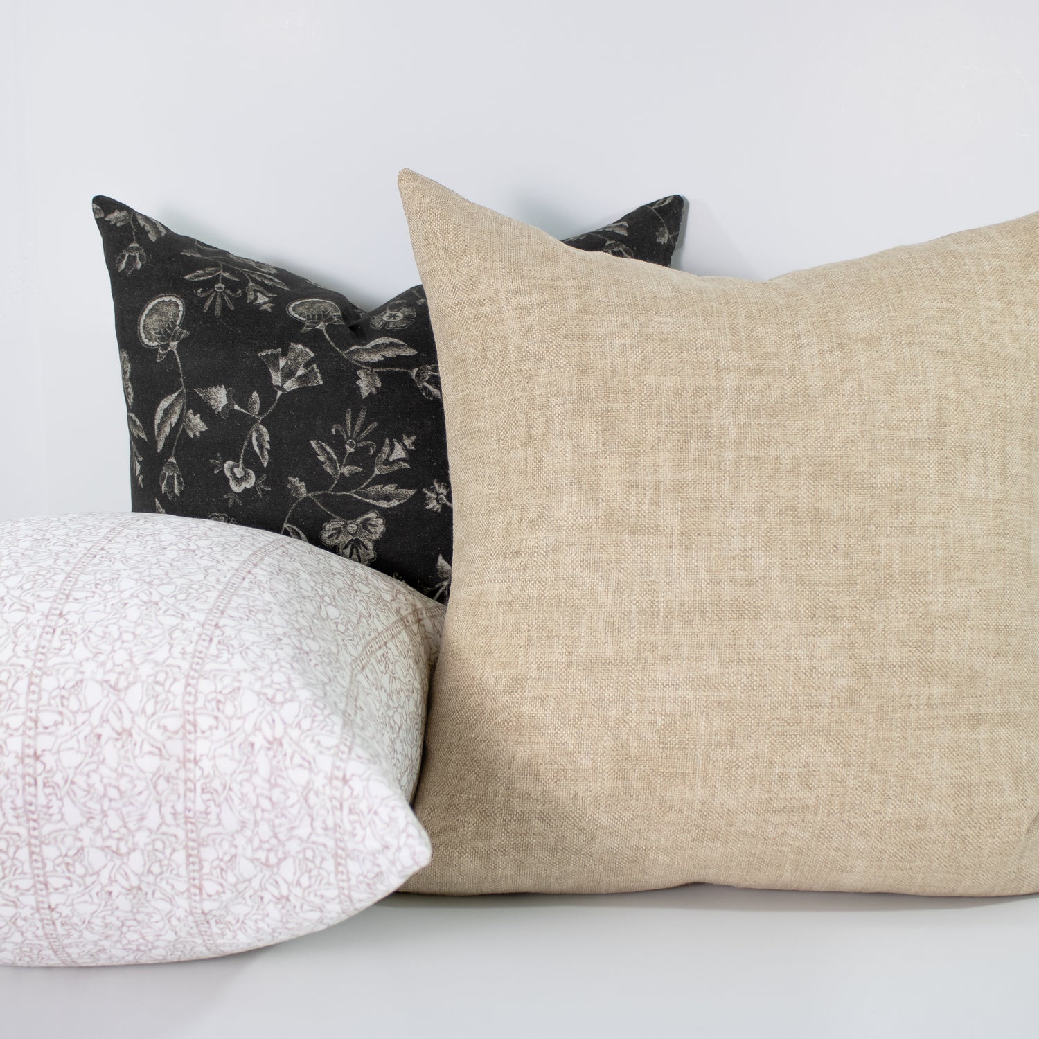 Three pillows with different patterns on a white background