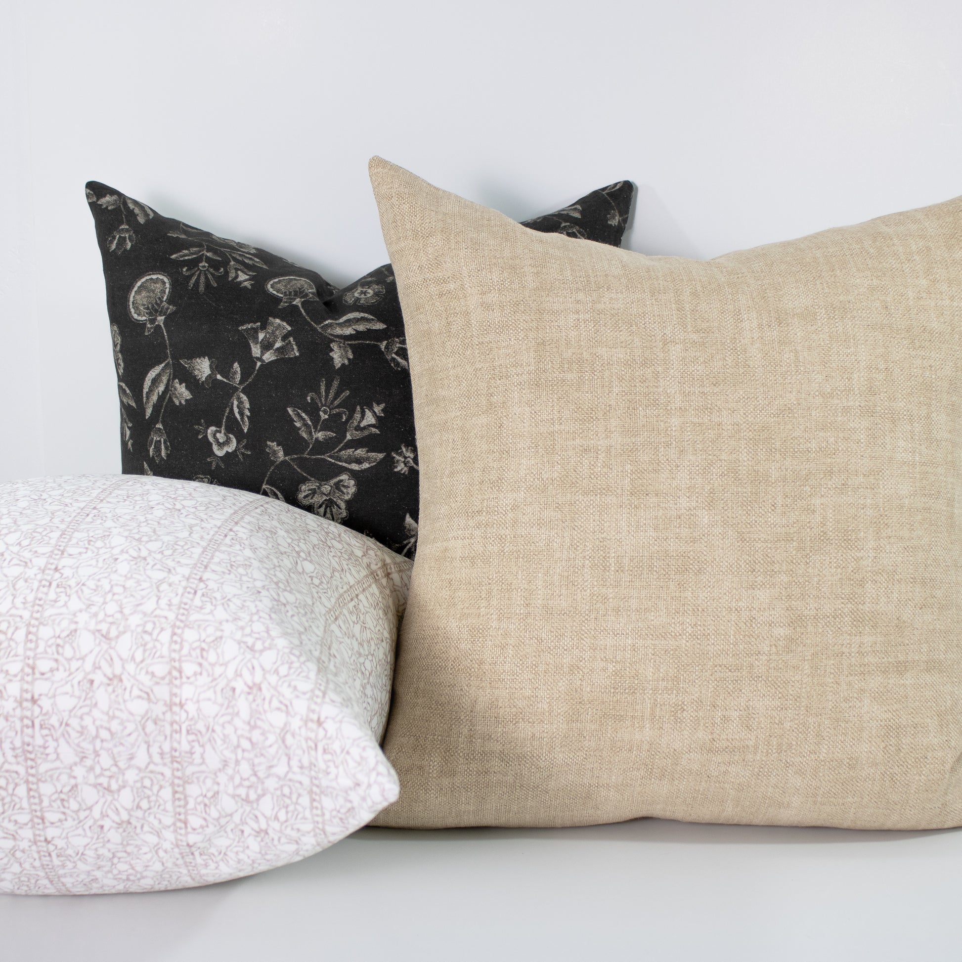 Three pillows with different patterns on a white background