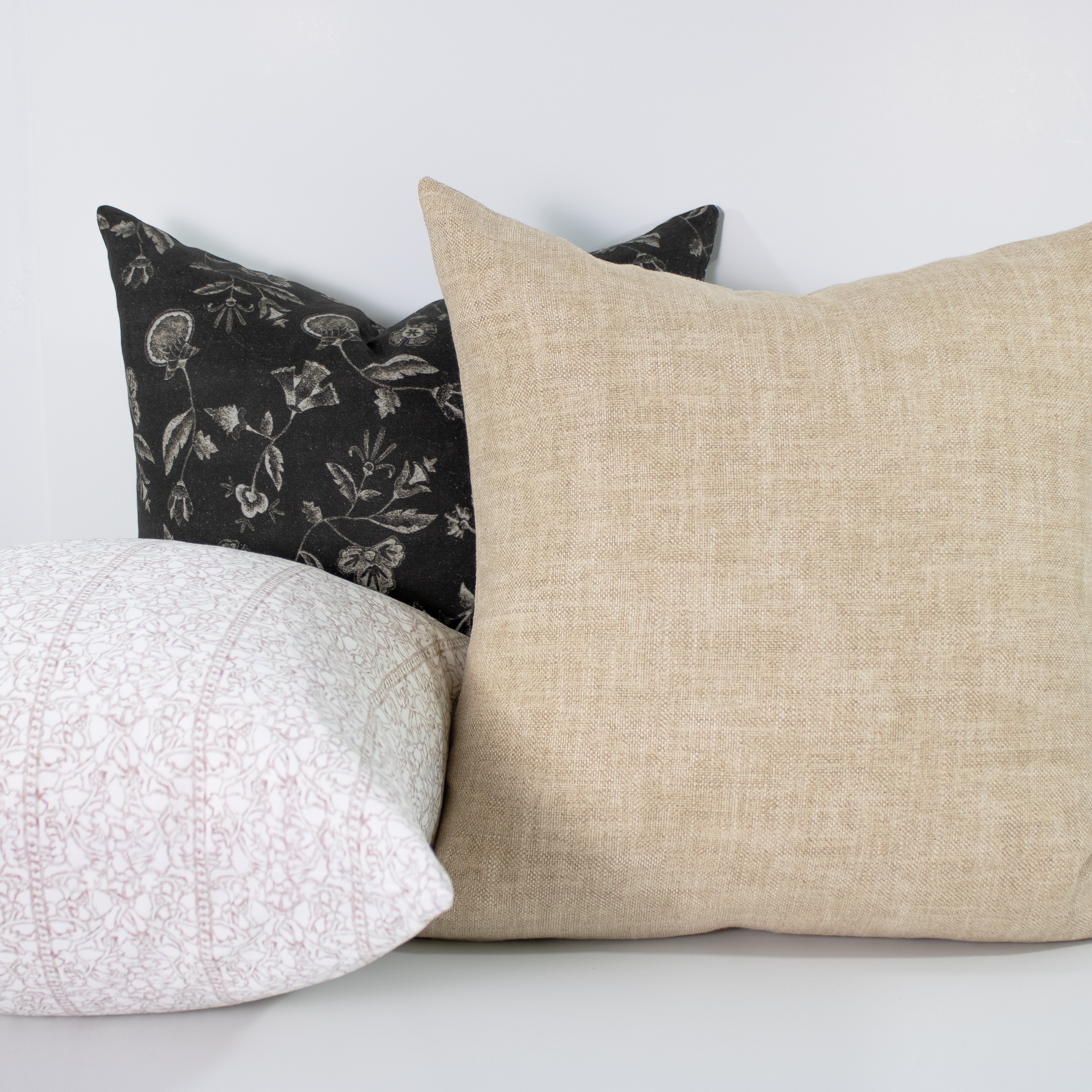 Three pillows with different patterns on a white background