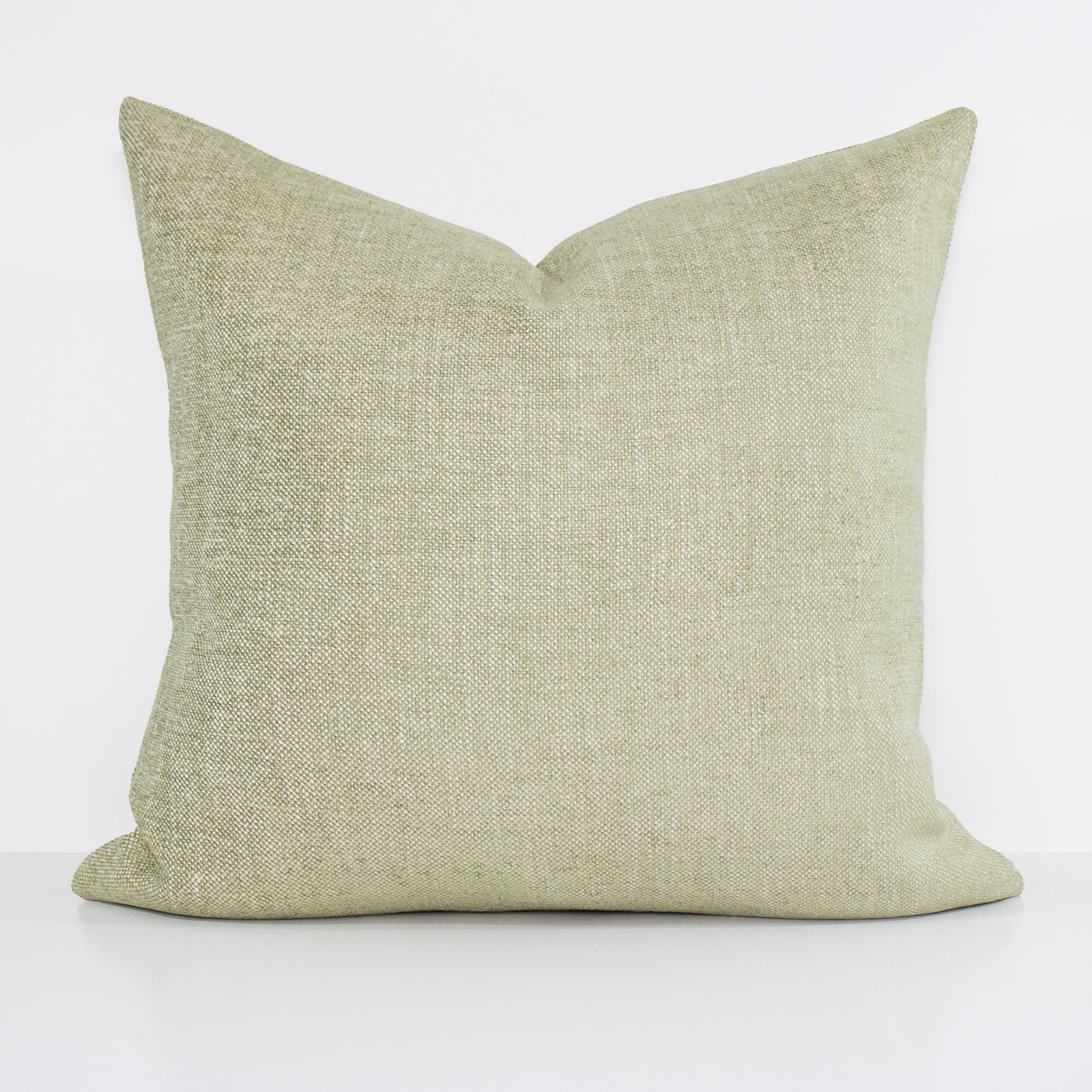 Green textured pillow on a white background