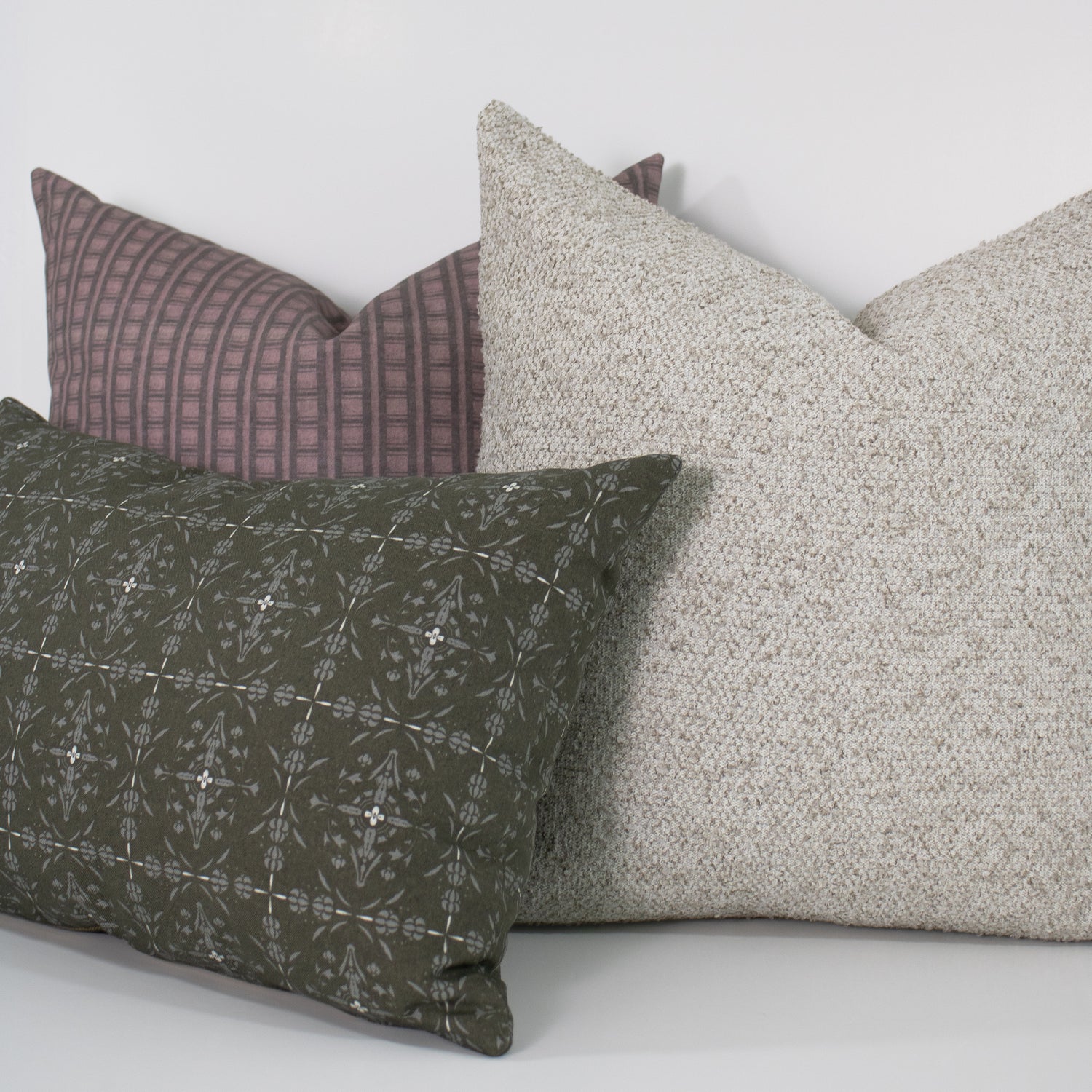 Three pillows in different patterns and colors on a white background