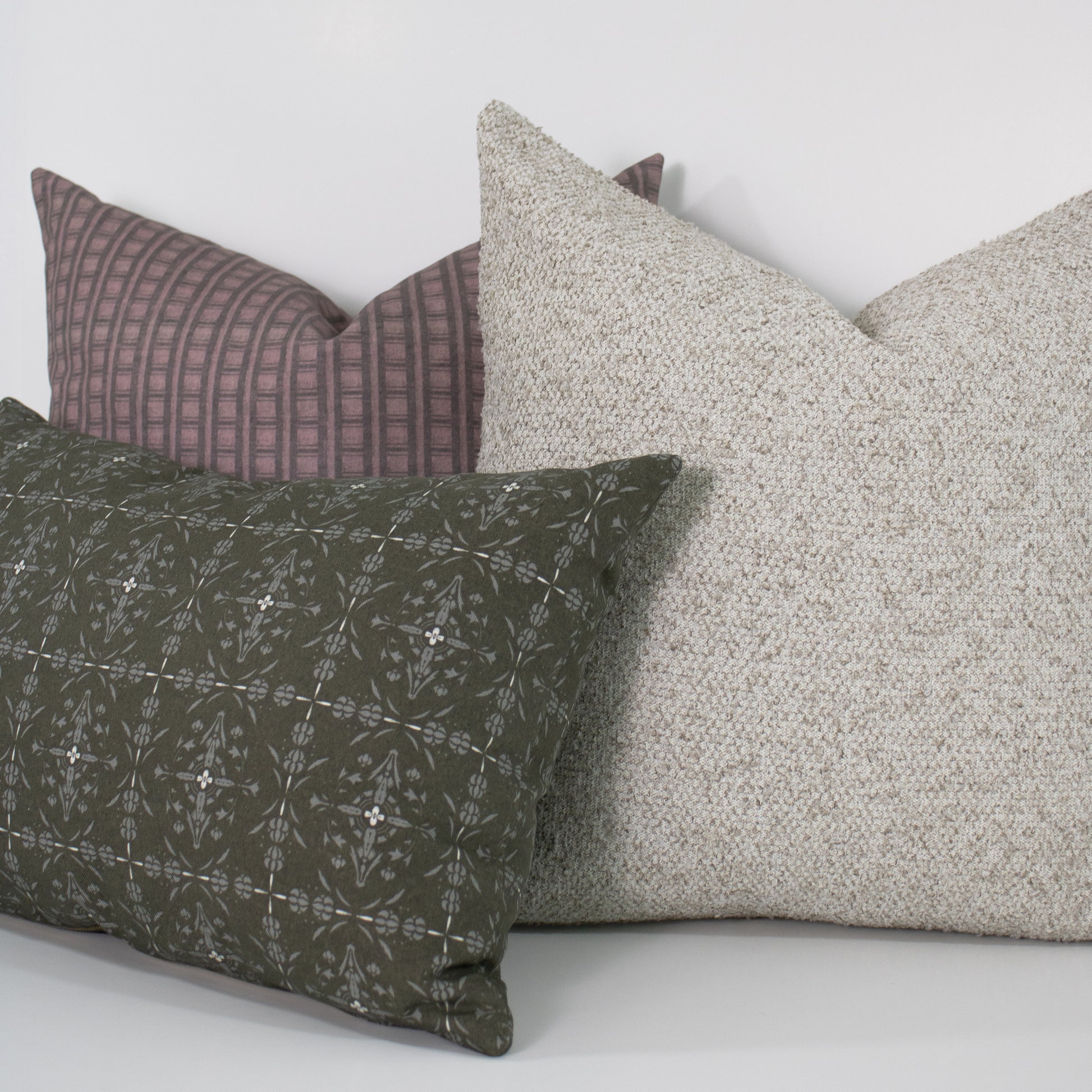 Three pillows in different patterns and colors on a white background