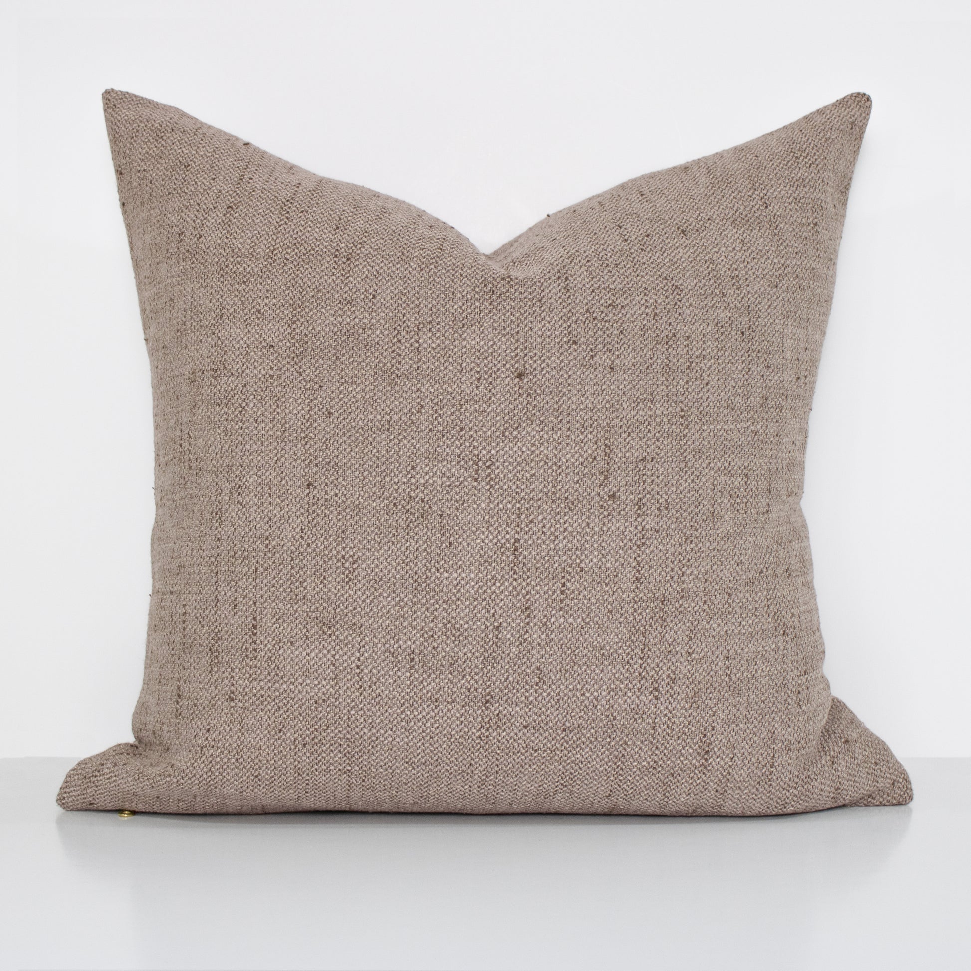 Textured light brown pillow on a white background