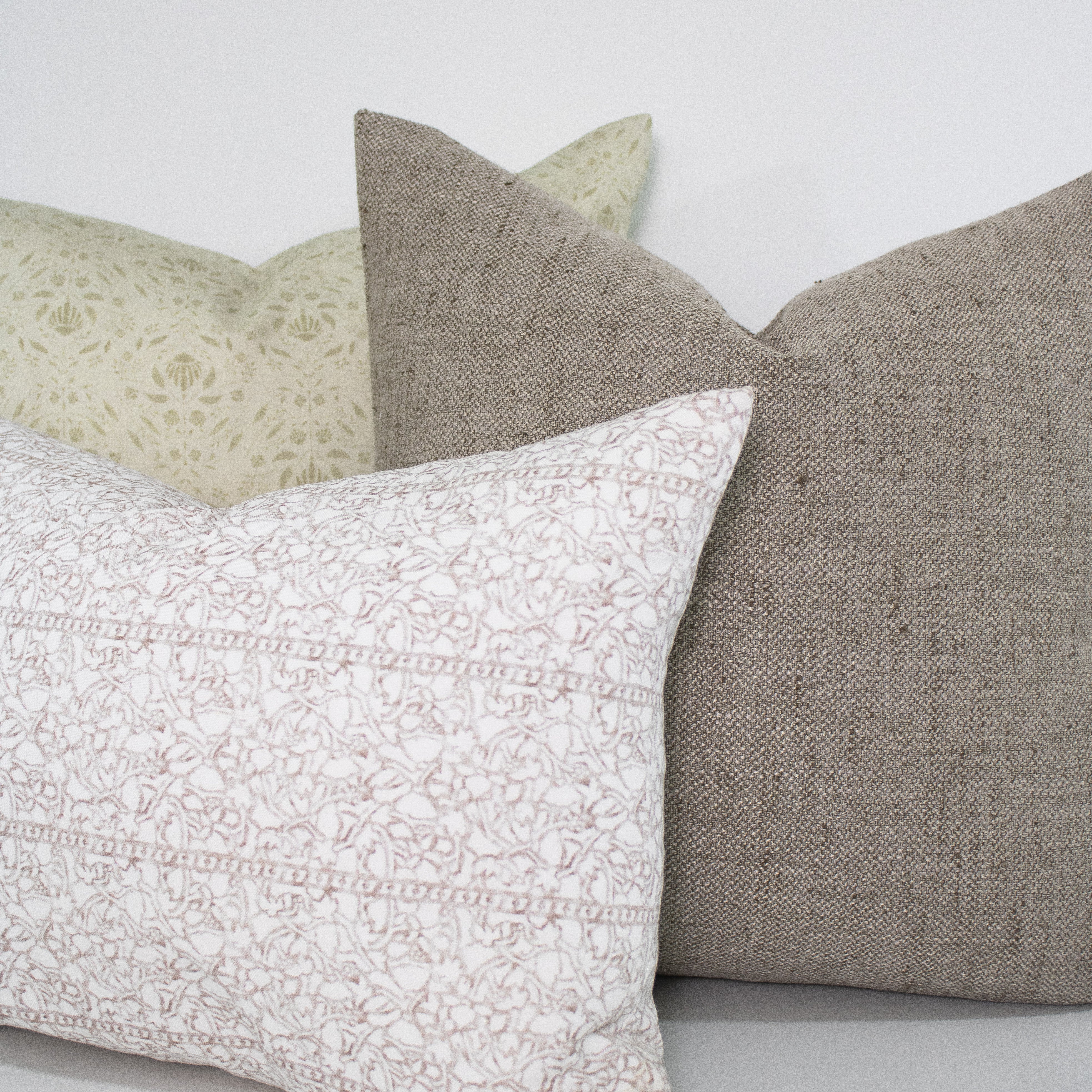 Four pillows in different patterns and colors on a light background