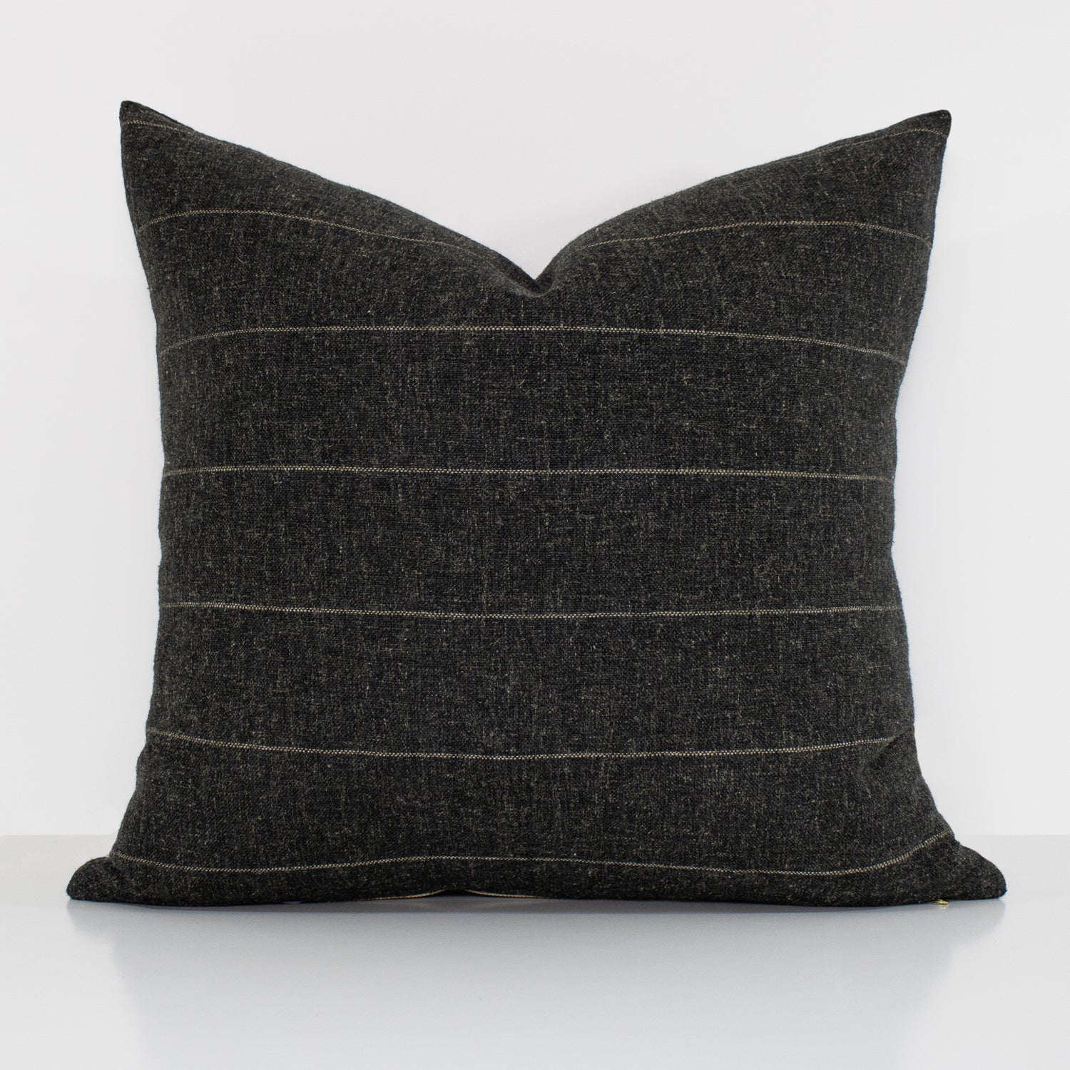 Dark gray pillow with horizontal stripes on a white background