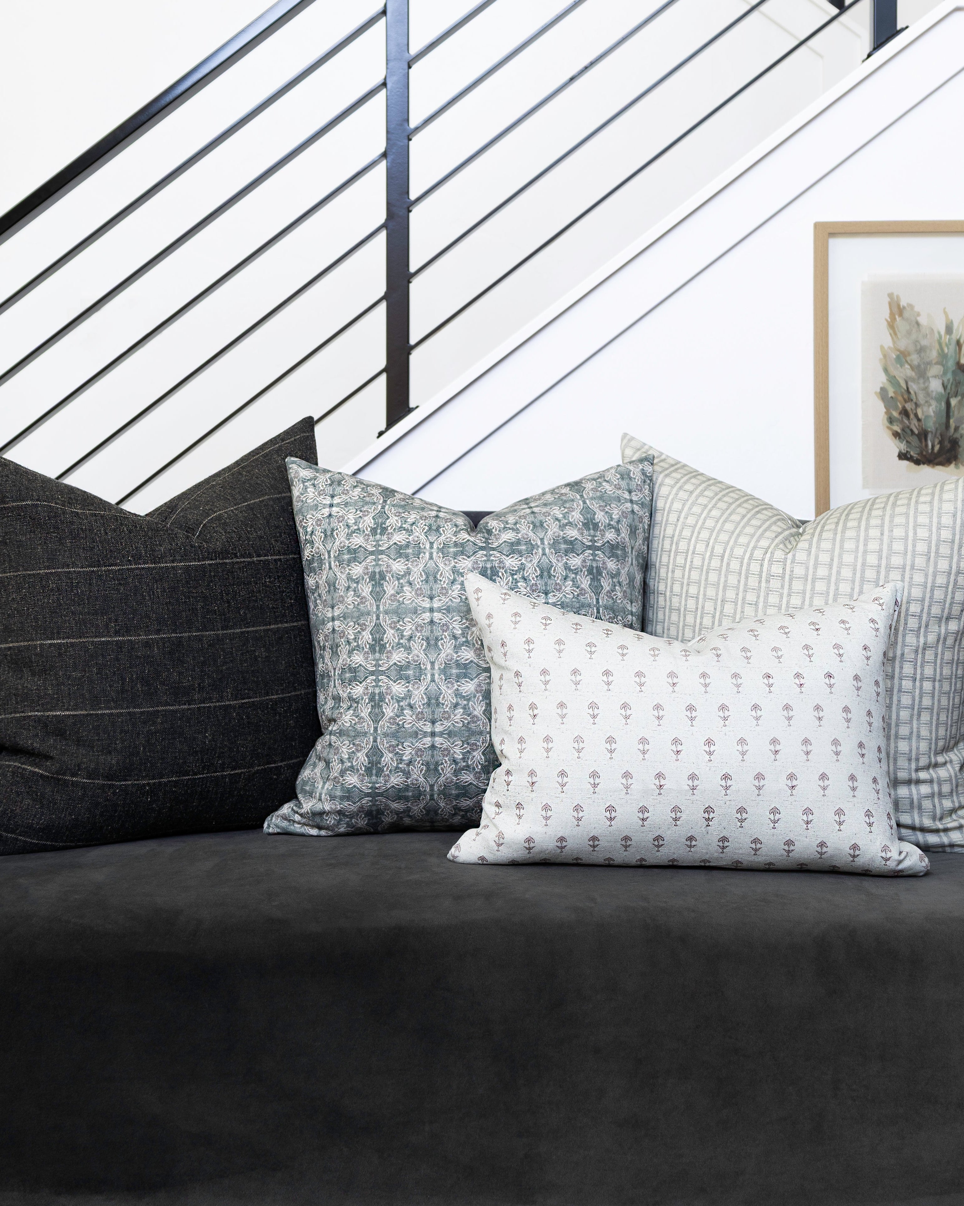 Gray sofa with patterned cushions in a modern living room setting.